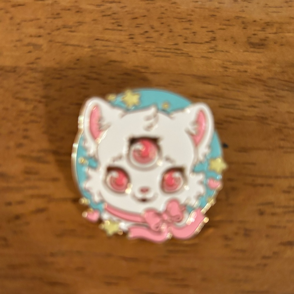 Bright Bat Design Three-Eyed Cat Enamel Pin featuring a pink bow